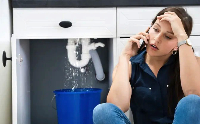 Aggravated woman with a leaky sink