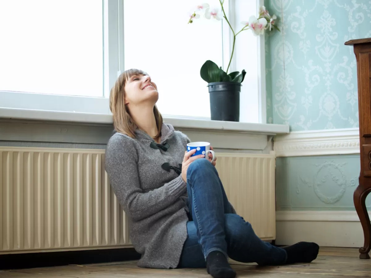 Woman next to heater with tea